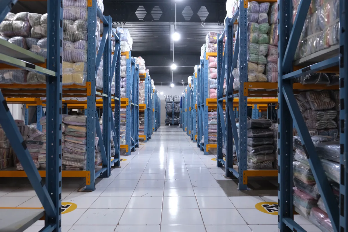 Rak gudang Lemone berisi stok pakaian grosir